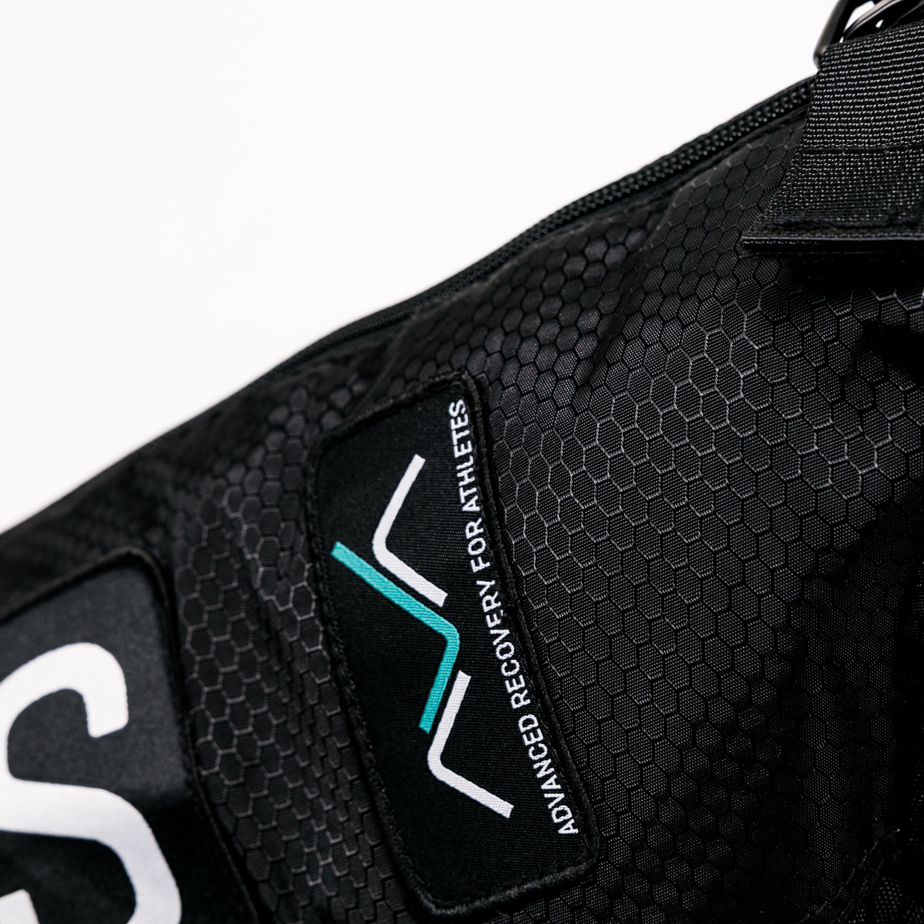 Detalhe em close-up da mochila de transporte AVABoots, mostrando o tecido texturizado em favo de mel, o fecho de correr e o logótipo bordado "AVA - Advanced Recovery for Athletes".