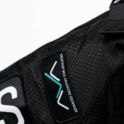 Detalhe em close-up da mochila de transporte AVABoots, mostrando o tecido texturizado em favo de mel, o fecho de correr e o logótipo bordado "AVA - Advanced Recovery for Athletes".