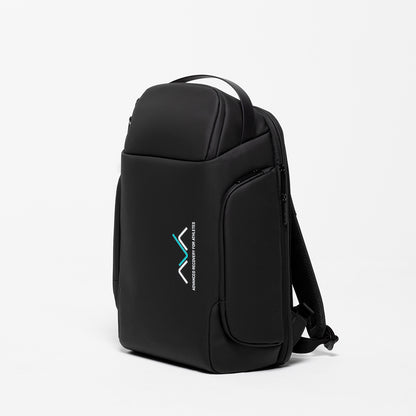 Mochila de transporte AVABoots em vista lateral, mochila técnica preta com compartimento para portátil, bolso frontal com fecho e logótipo AVA em branco e turquesa, fotografada sobre fundo branco.